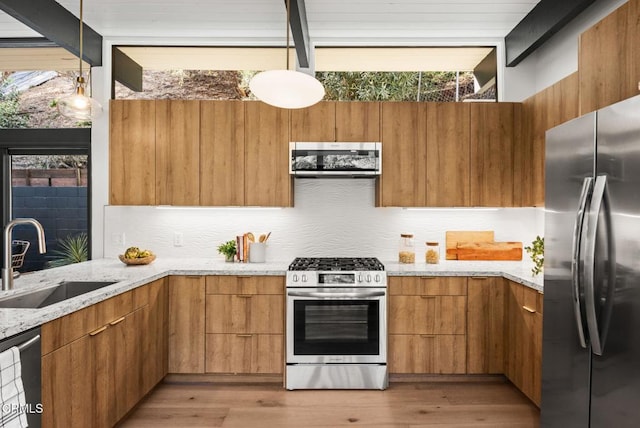 kitchen featuring tasteful backsplash, appliances with stainless steel finishes, sink, and pendant lighting