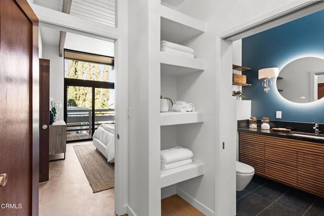 bathroom featuring vanity, built in shelves, and toilet