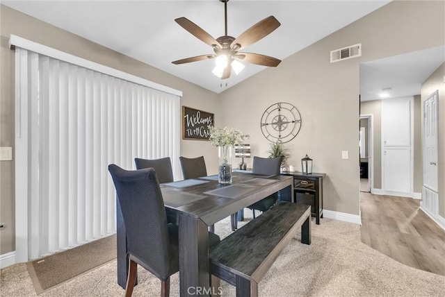 carpeted dining area featuring lofted ceiling and ceiling fan