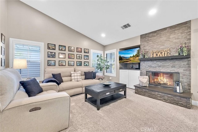 living room featuring high vaulted ceiling, light colored carpet, and a fireplace