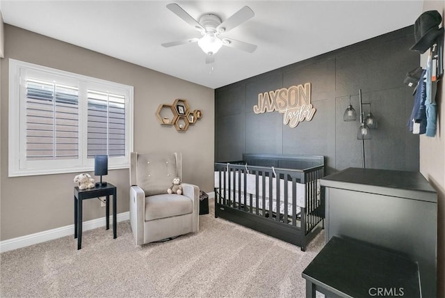 bedroom featuring ceiling fan, carpet flooring, and a crib