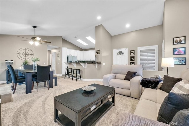 living room featuring ceiling fan, vaulted ceiling, and light carpet