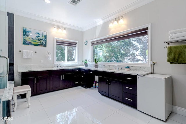 bathroom featuring tile patterned flooring, vanity, a shower with shower door, and ornamental molding