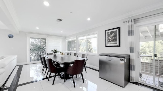 tiled dining area featuring ornamental molding and a wealth of natural light