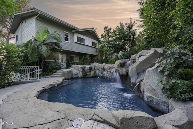 pool at dusk with pool water feature