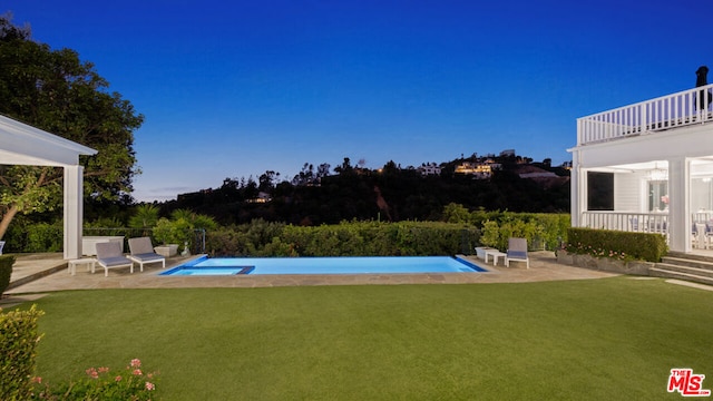 view of pool with a lawn and a patio area