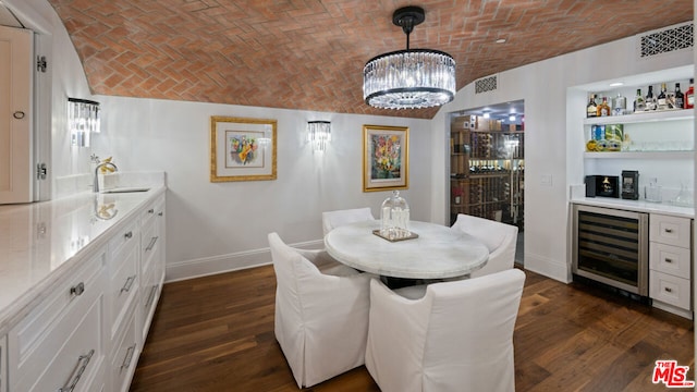 dining area with brick ceiling, indoor wet bar, beverage cooler, dark wood-type flooring, and an inviting chandelier