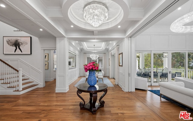 foyer entrance featuring coffered ceiling, crown molding, wood-type flooring, and a chandelier