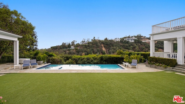 view of pool with a lawn and a patio area