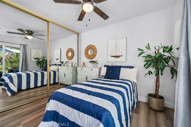 bedroom with a closet, dark hardwood / wood-style floors, and ceiling fan