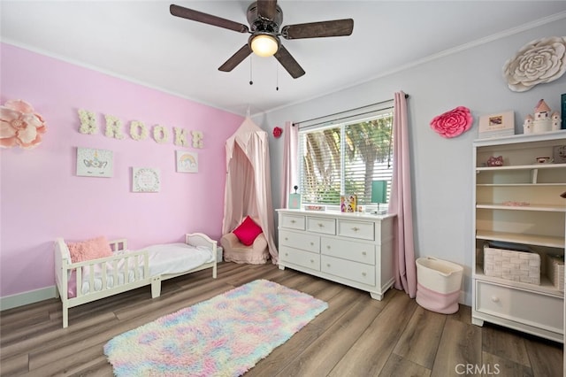 bedroom featuring ornamental molding, dark wood-type flooring, and ceiling fan