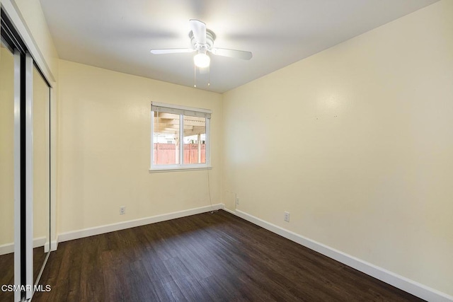 unfurnished bedroom with dark wood-type flooring, ceiling fan, and a closet