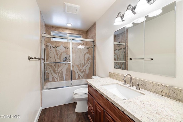 full bathroom featuring enclosed tub / shower combo, vanity, toilet, and wood-type flooring