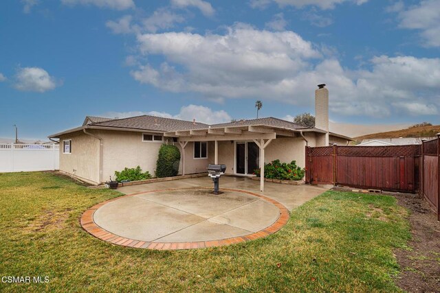 rear view of property featuring a yard and a patio area