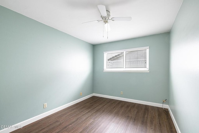 spare room featuring dark wood-type flooring and ceiling fan