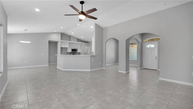 unfurnished living room featuring lofted ceiling, ceiling fan, and light tile patterned flooring