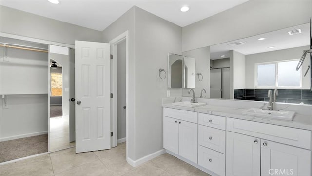 bathroom featuring tile patterned flooring, vanity, and a shower with door