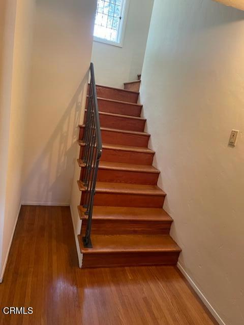 stairway with hardwood / wood-style floors