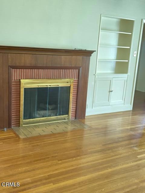 details featuring a brick fireplace and hardwood / wood-style flooring