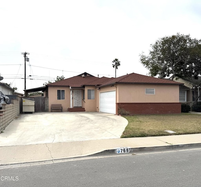 single story home featuring a garage and a front yard