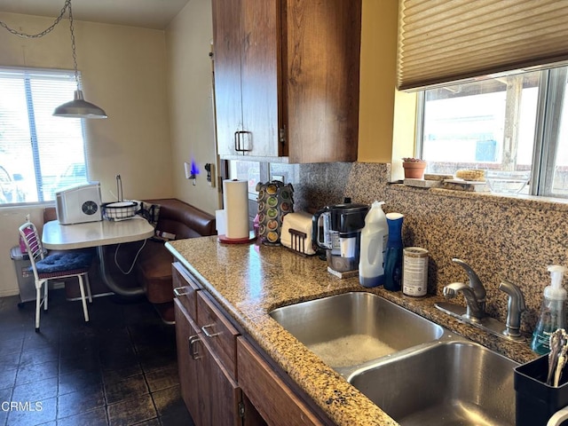 kitchen with sink, hanging light fixtures, and backsplash