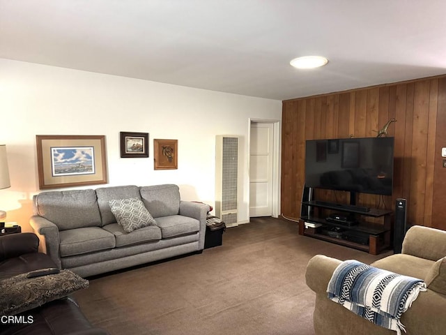 carpeted living room with wooden walls