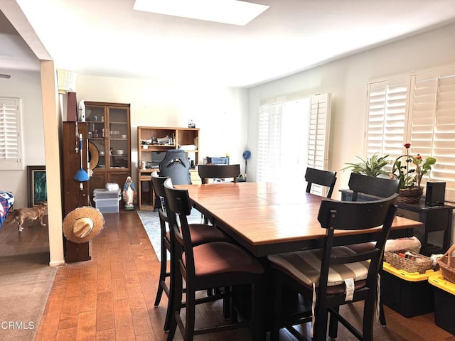 dining area with a skylight and dark wood-type flooring