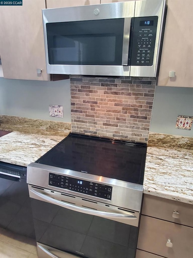 kitchen featuring stainless steel appliances, tasteful backsplash, and light stone counters