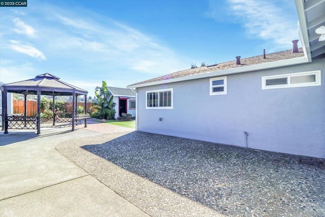 view of side of home featuring a gazebo and a patio area