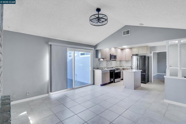 kitchen featuring lofted ceiling, sink, stainless steel appliances, a center island, and light brown cabinetry