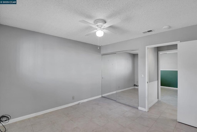 unfurnished bedroom featuring ceiling fan, a closet, and a textured ceiling