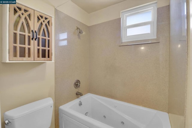 bathroom featuring tiled shower / bath and toilet