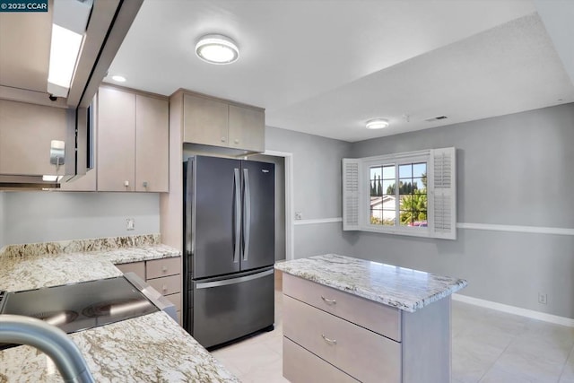 kitchen featuring light stone counters and refrigerator