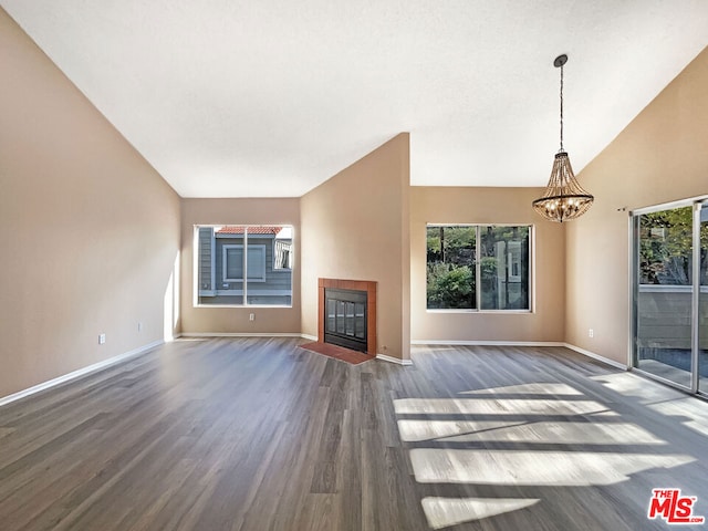 unfurnished living room with lofted ceiling, dark hardwood / wood-style floors, and a wealth of natural light