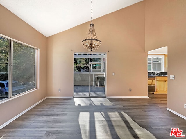 unfurnished dining area with an inviting chandelier, sink, dark hardwood / wood-style flooring, and high vaulted ceiling