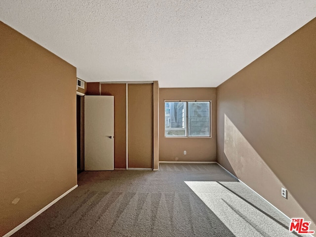 unfurnished bedroom with carpet floors and a textured ceiling