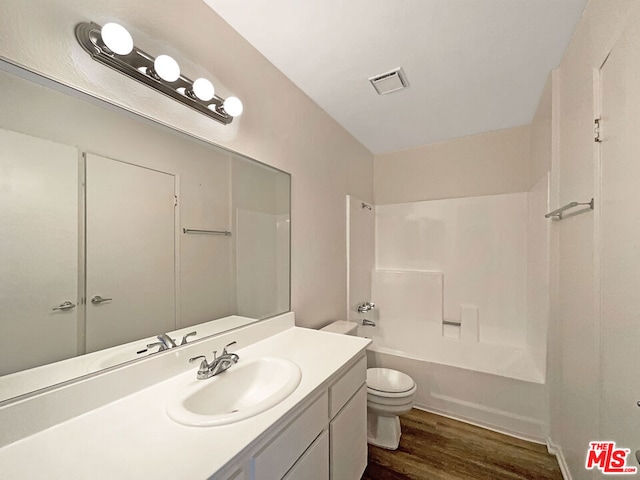 full bathroom with wood-type flooring, toilet, vanity, and shower / tub combination