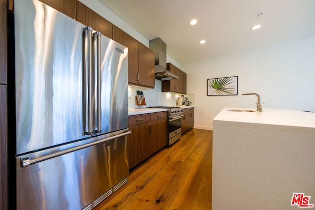 kitchen featuring dark hardwood / wood-style floors, sink, backsplash, and premium appliances