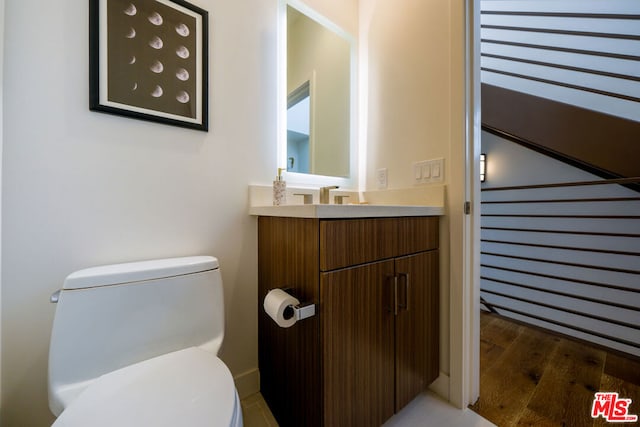 bathroom featuring hardwood / wood-style flooring, vanity, and toilet