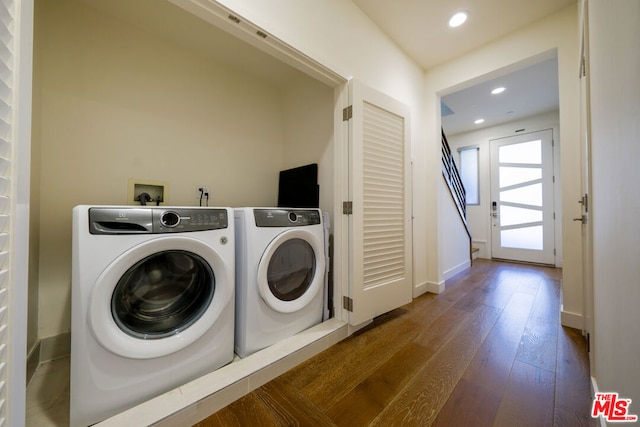 clothes washing area featuring dark hardwood / wood-style flooring and washer and dryer