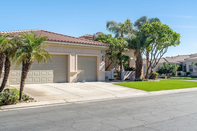 mediterranean / spanish-style house with a garage and a front lawn