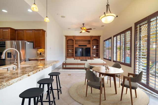 dining area with sink, ceiling fan, and light tile patterned flooring