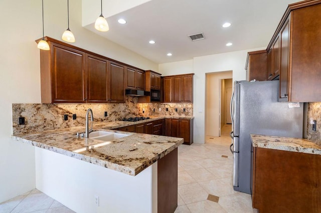 kitchen with kitchen peninsula, decorative light fixtures, sink, light stone counters, and black appliances