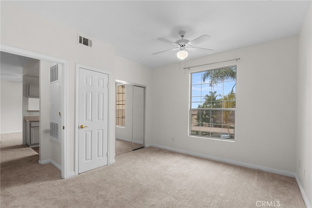 unfurnished bedroom featuring light carpet and ceiling fan