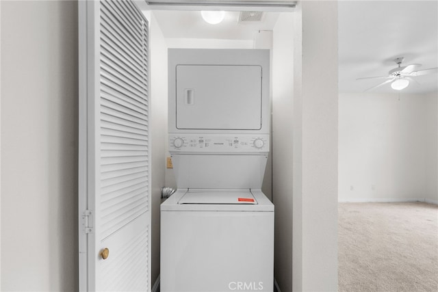 laundry area featuring ceiling fan, stacked washing maching and dryer, and carpet floors