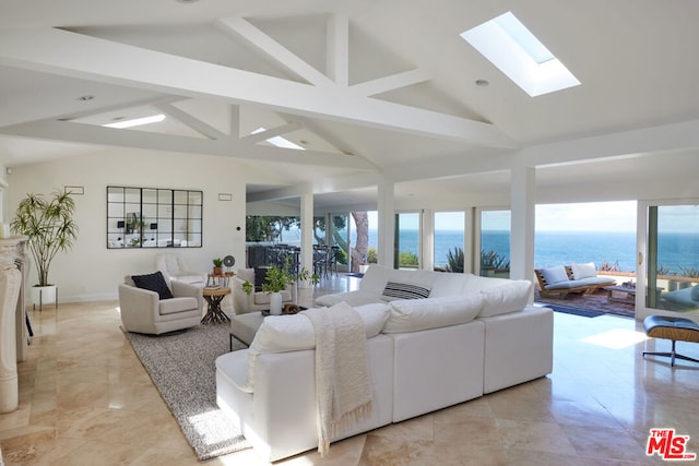 living room featuring a water view, plenty of natural light, a skylight, and high vaulted ceiling