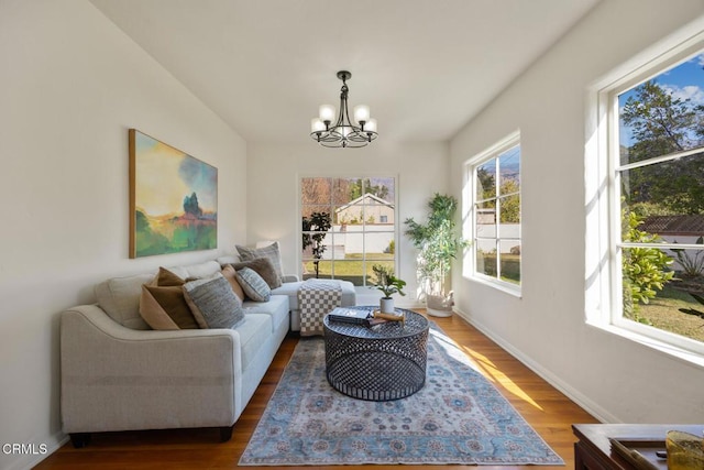 living room featuring wood-type flooring and an inviting chandelier