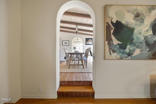 hallway with vaulted ceiling with beams and hardwood / wood-style flooring