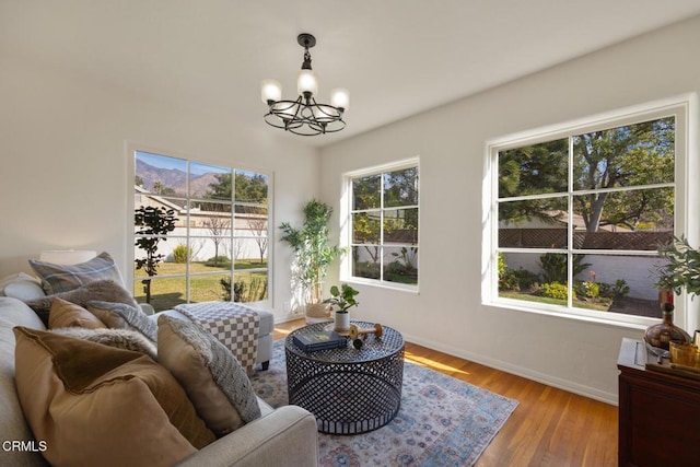 living room featuring an inviting chandelier, plenty of natural light, and light hardwood / wood-style flooring