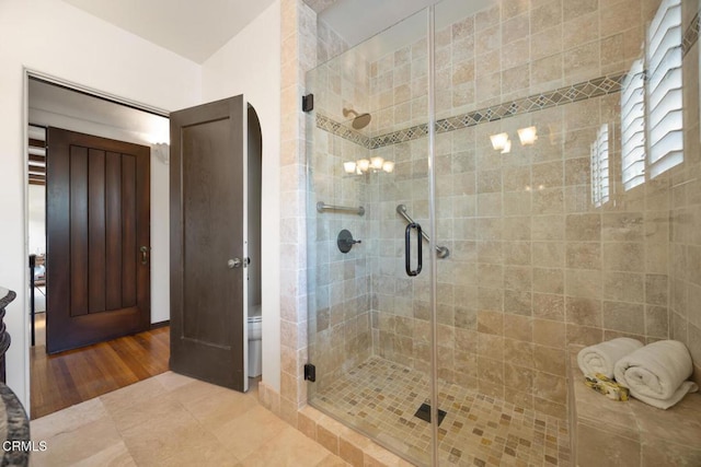 bathroom featuring hardwood / wood-style flooring and an enclosed shower